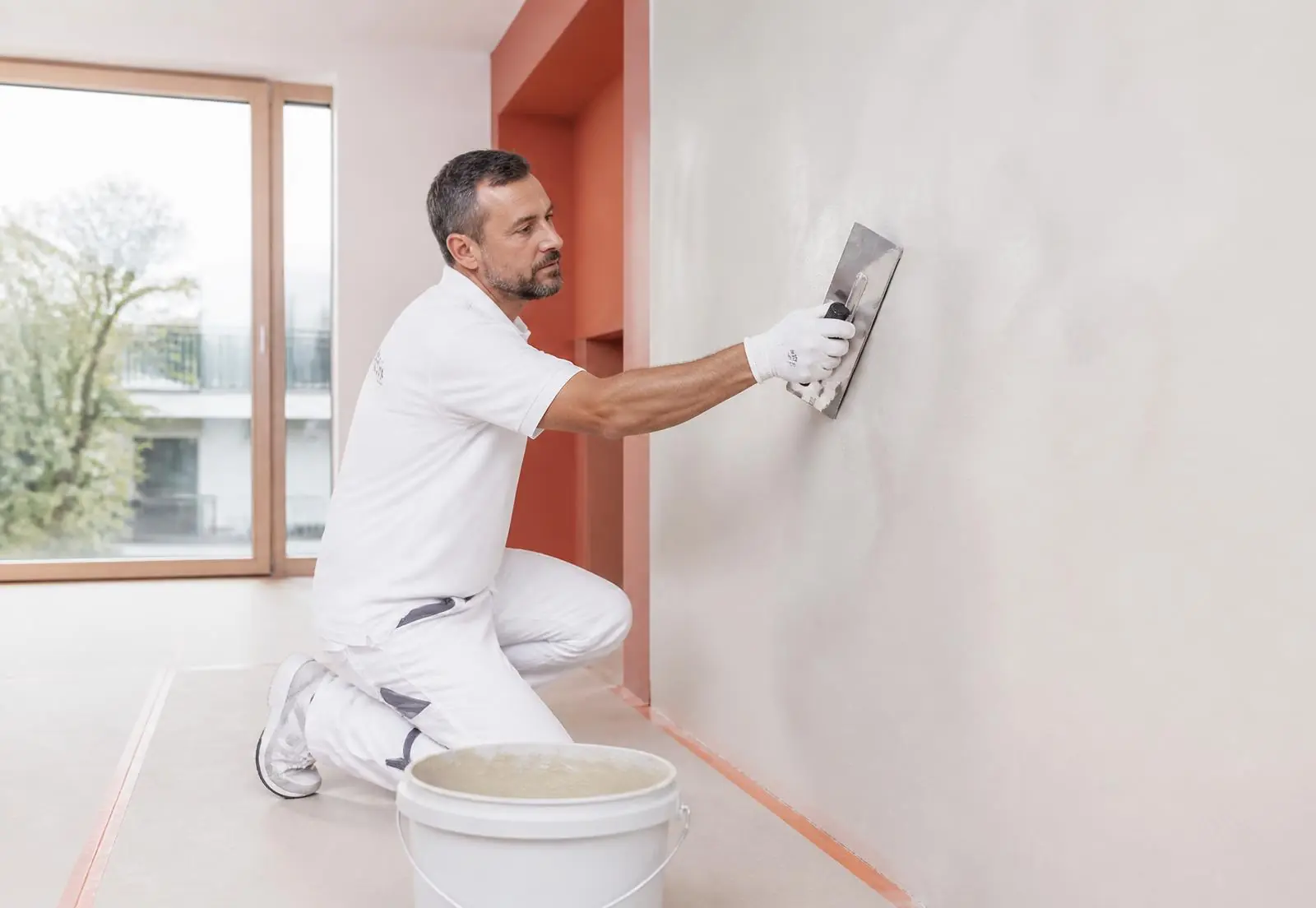 Gessatore MAD Service esegue una rasatura a gesso su parete interna in un appartamento a Lugano